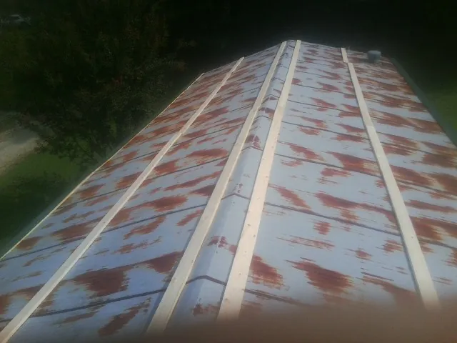 Rusted metal roof panels with new wood purlins before replacement — Storm Damage Roof Repair in Moncure by Roofing Brothers