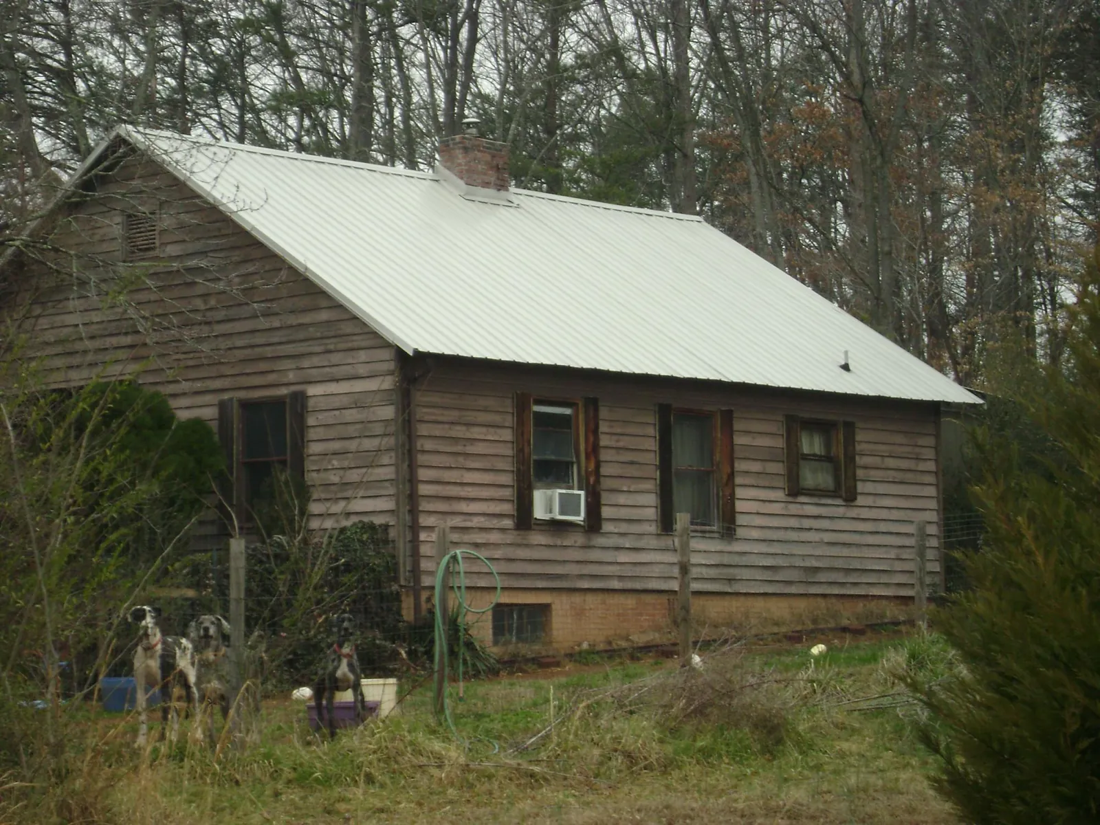 White metal roof on an old wood sided farmhouse, from a Metal Roof Installation job in Moncure